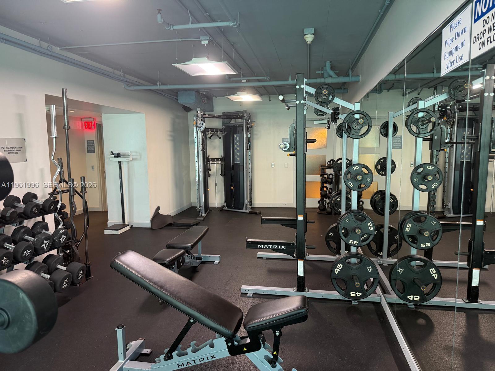 60 Southwest 13th Street, Unit 1107 Miami, FL 33130 - Photo 37 of 47 a room with gym equipment and mirror