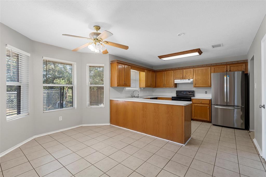 4609 Lexington Street Waco, TX 76705 - Photo 11 of 25 a kitchen with granite countertop a refrigerator and a stove top oven