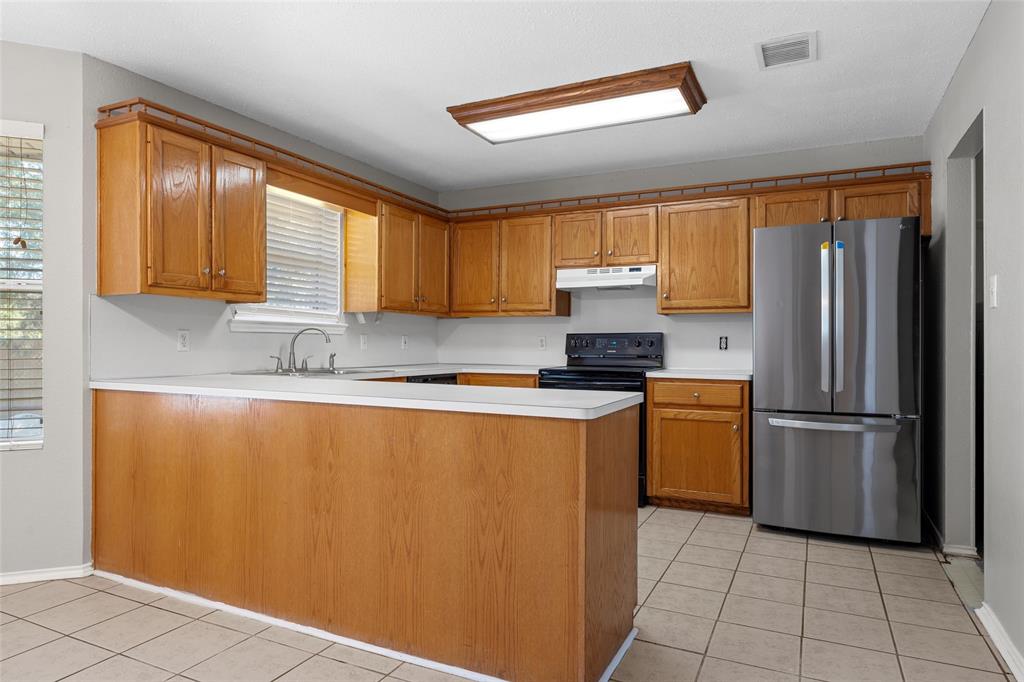 4609 Lexington Street Waco, TX 76705 - Photo 14 of 25 a kitchen with stainless steel appliances granite countertop a refrigerator sink and cabinets