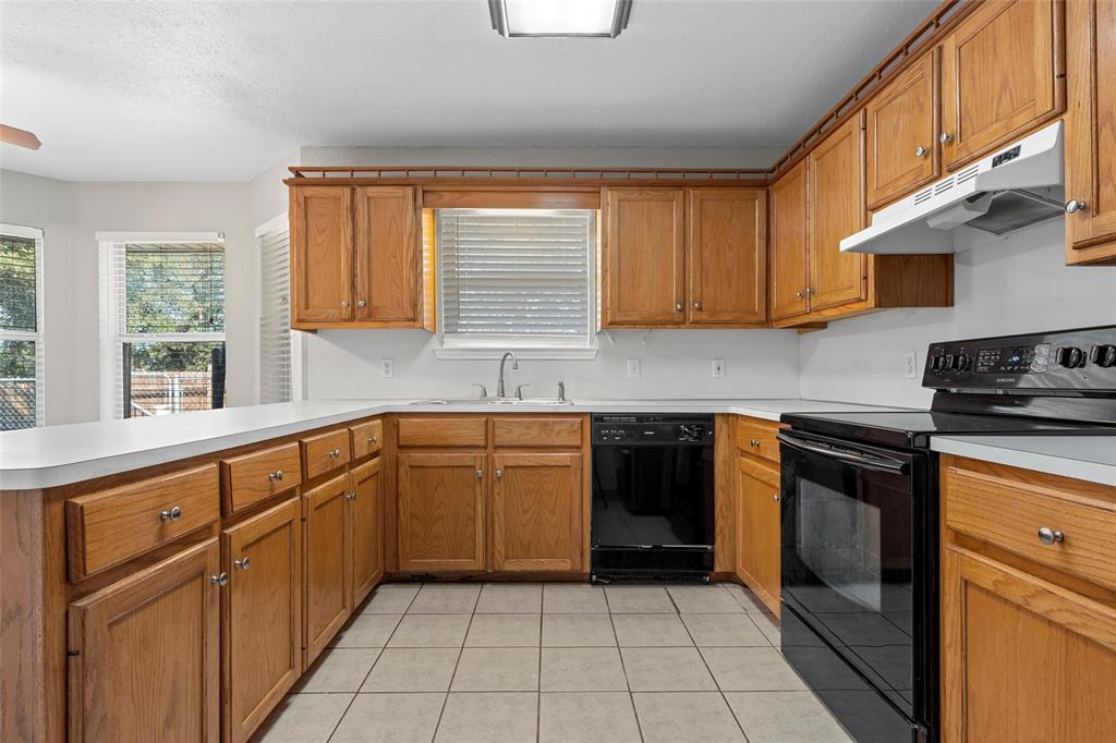 4609 Lexington Street Waco, TX 76705 - Photo 16 of 25 a kitchen with stainless steel appliances granite countertop a stove a sink and a white cabinets