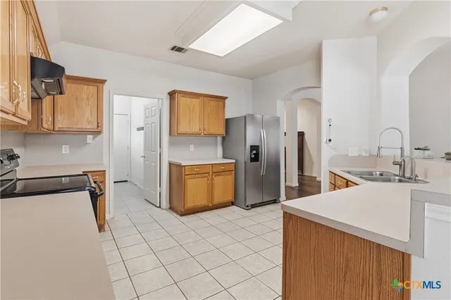 a kitchen with stainless steel appliances a sink and a refrigerator