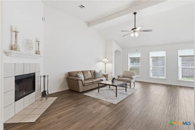 a living room with furniture a fireplace and wooden floor
