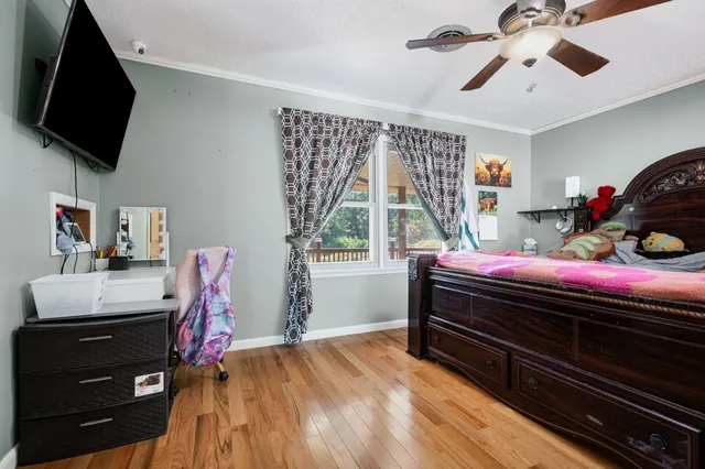 a bedroom with a bed window and a flat screen tv