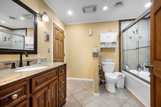 a bathroom with a granite countertop sink toilet and mirror