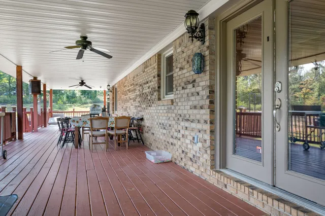 a view of a patio with table and chairs and floor to ceiling window with wooden floor