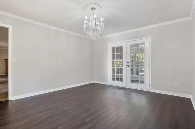 a kitchen with white cabinets appliances and a window