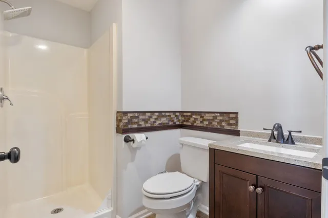 a bathroom with a sink a toilet and shower