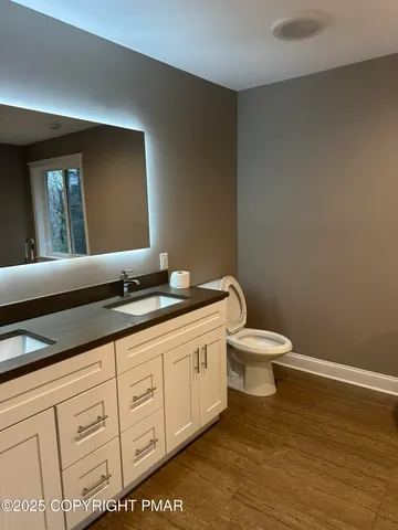 a bathroom with a granite countertop toilet sink and mirror
