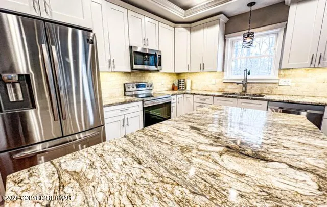 a kitchen with stainless steel appliances granite countertop a refrigerator sink and stove