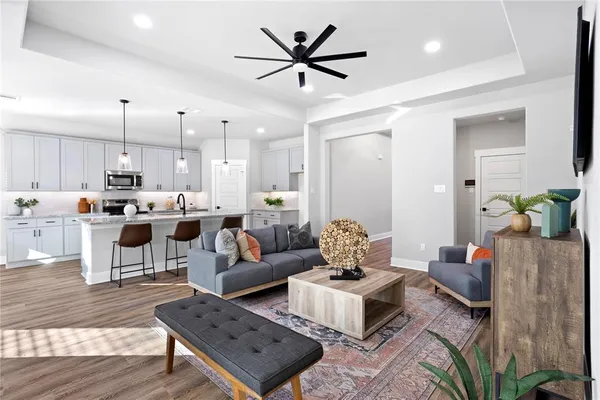 a living room with lots of furniture and kitchen view