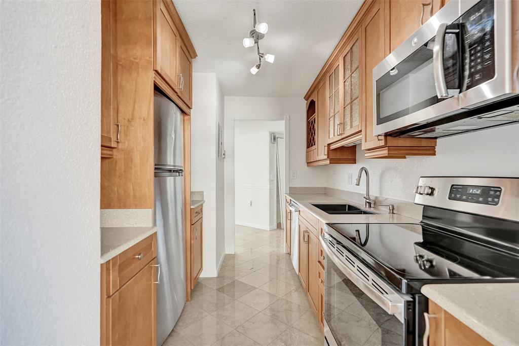 710 North Ocean Boulevard, Unit 910 Pompano Beach, FL 33062 - Photo 12 of 65 a kitchen with stainless steel appliances granite countertop a stove and a refrigerator
