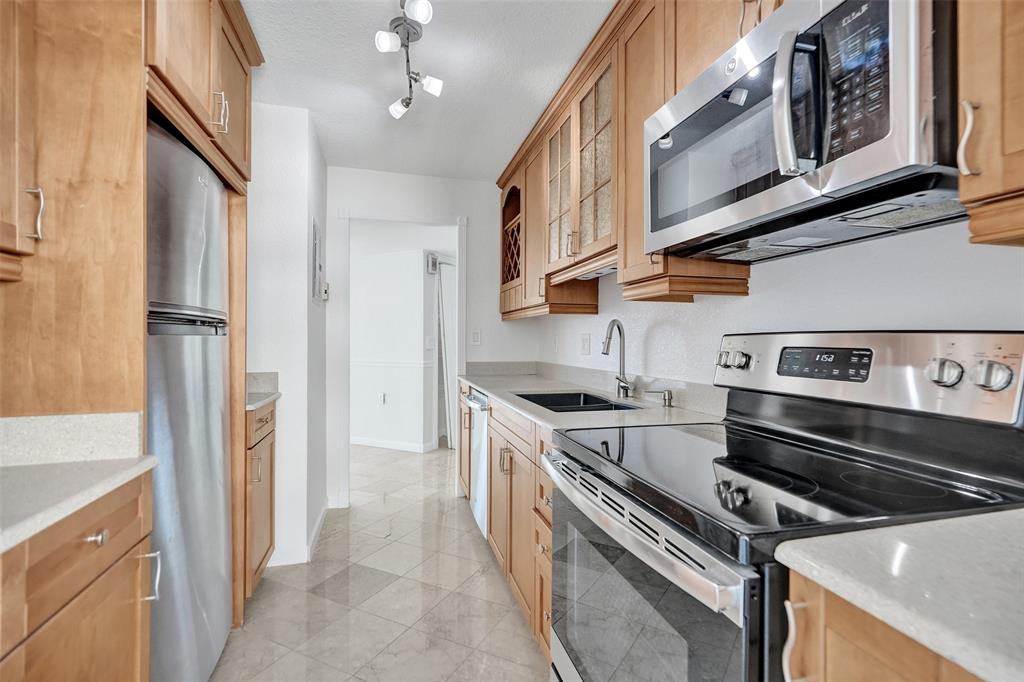 710 North Ocean Boulevard, Unit 910 Pompano Beach, FL 33062 - Photo 13 of 65 a kitchen with stainless steel appliances granite countertop a stove and a refrigerator