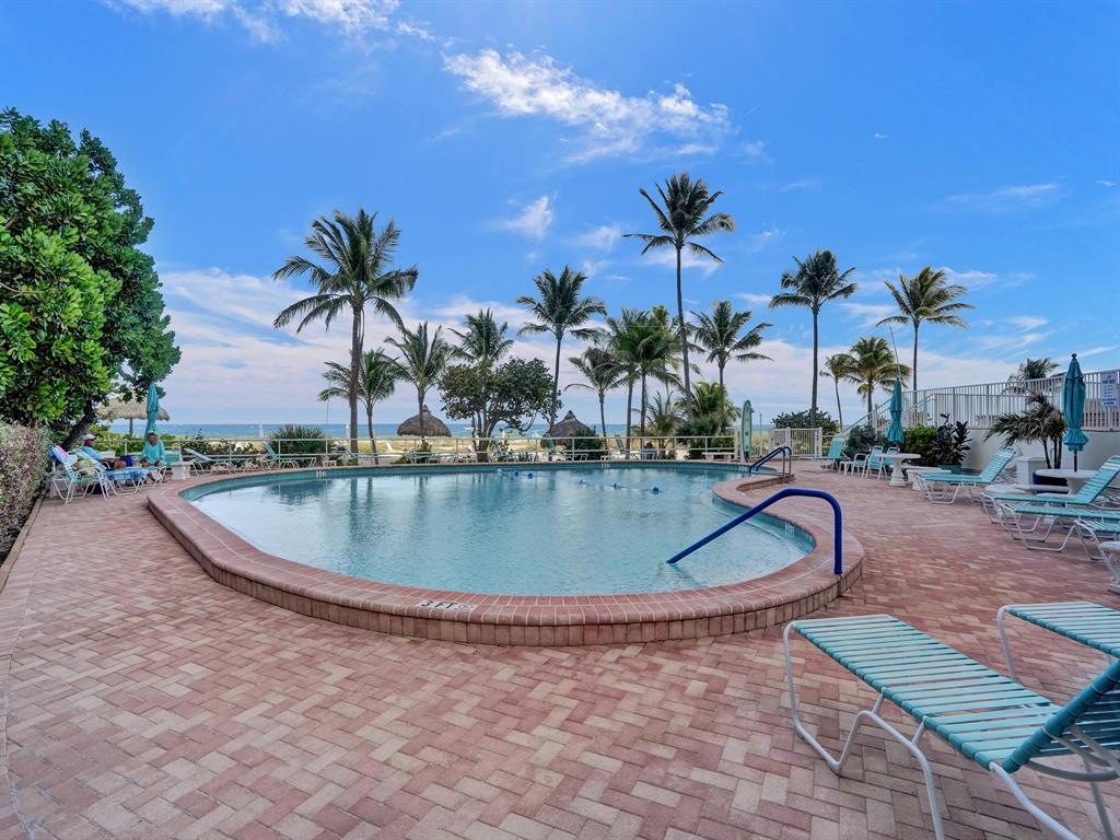 710 North Ocean Boulevard, Unit 910 Pompano Beach, FL 33062 - Photo 45 of 65 a view of a swimming pool with a table and chairs