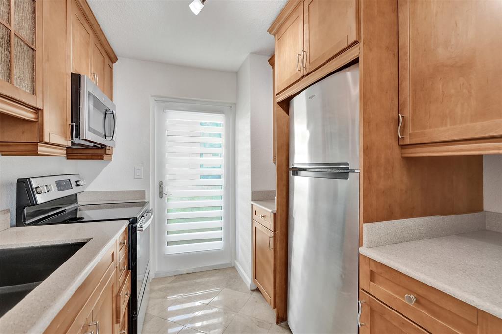 710 North Ocean Boulevard, Unit 910 Pompano Beach, FL 33062 - Photo 8 of 65 a kitchen with a refrigerator and a sink