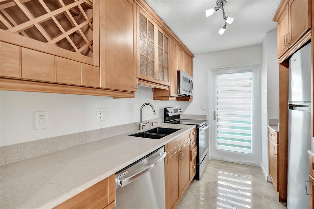 710 North Ocean Boulevard, Unit 910 Pompano Beach, FL 33062 - Photo 10 of 65 a kitchen with stainless steel appliances granite countertop a sink and cabinets