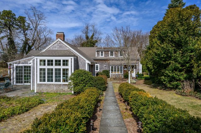 a front view of a house with a yard outdoor seating and green space