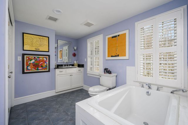 a living room with furniture a rug a fireplace and a large window