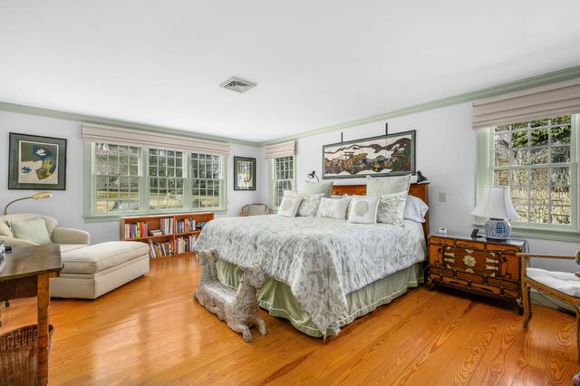 a spacious bedroom with a bed and a flat screen tv