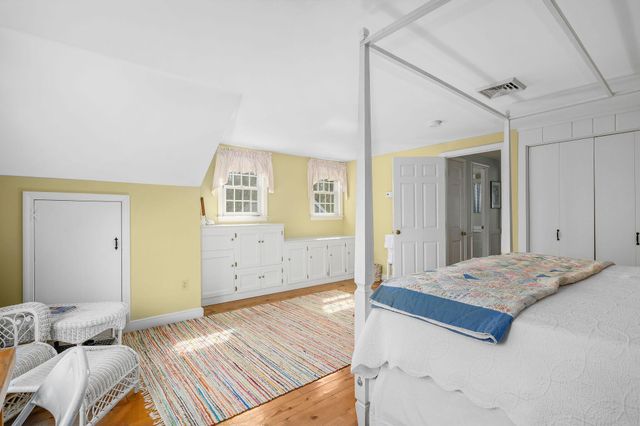 a bedroom with a bed and painting on the wall