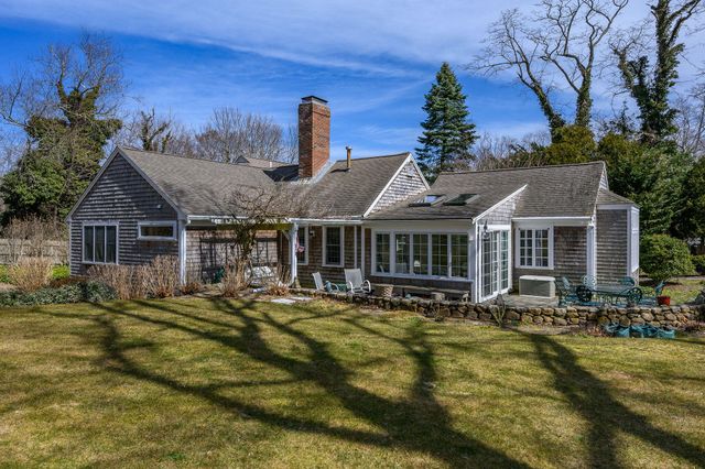 a front view of a house with a yard table and chairs