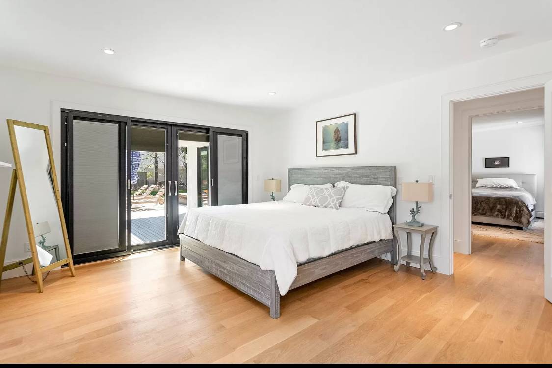 1 High Point Road East Hampton, NY 11937 - Photo 7 of 12 a spacious bedroom with a bed and a large window