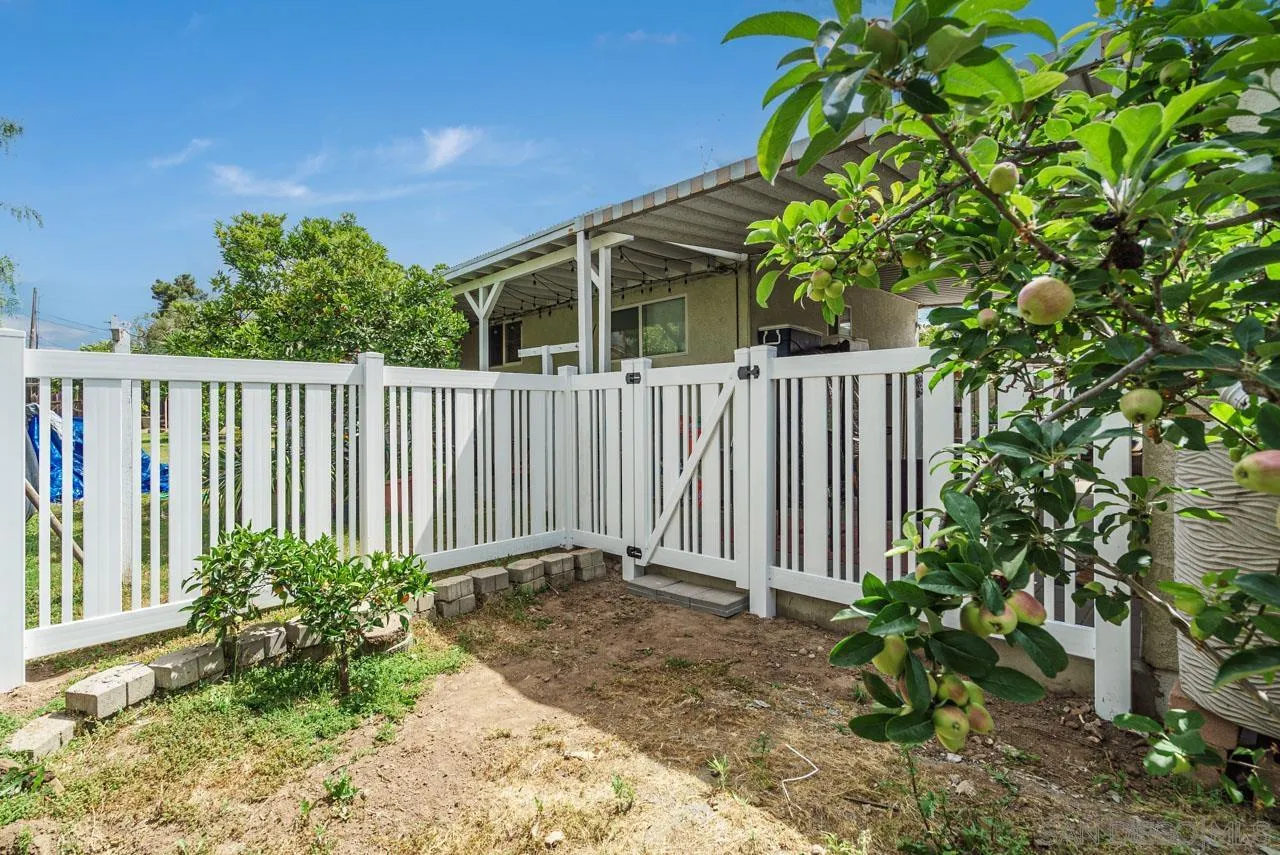 9026 Avocado Street Spring Valley, CA 91977 - Photo 24 of 27 a view of a house with a small yard and flower plants