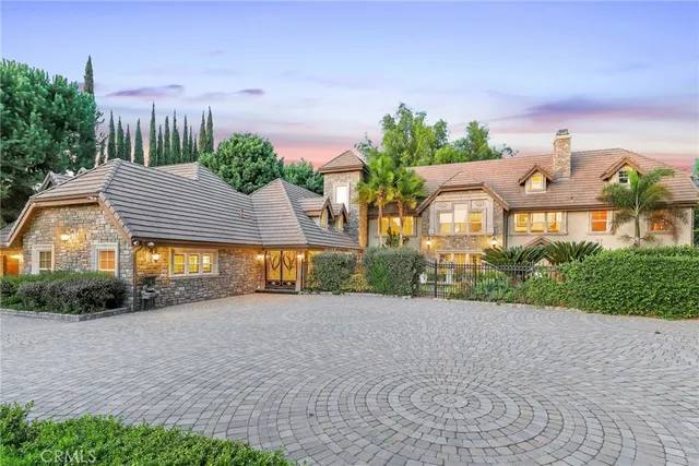 a front view of a house with a yard and potted plants