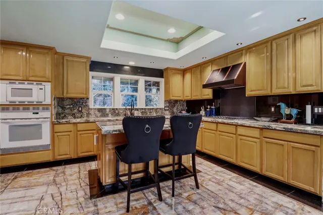a kitchen with granite countertop a sink stove and cabinets