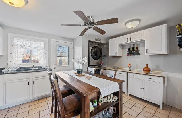 a kitchen with stainless steel appliances a sink a stove a dining table and chairs