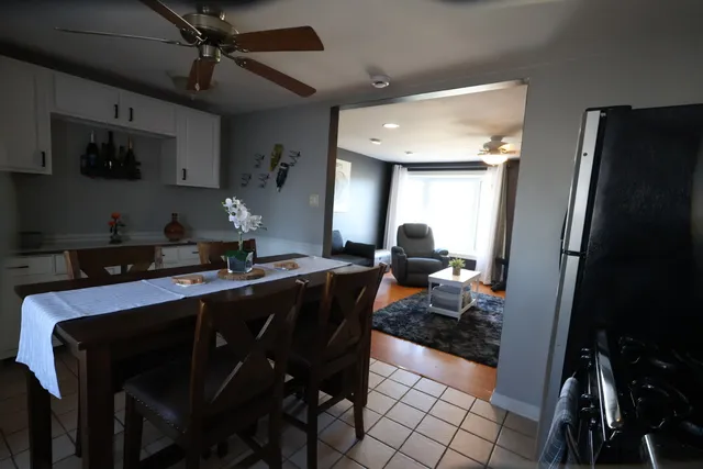 a kitchen with a table chairs refrigerator and cabinets