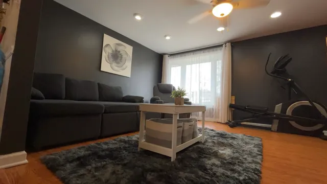 a living room with furniture a window and gym equipment