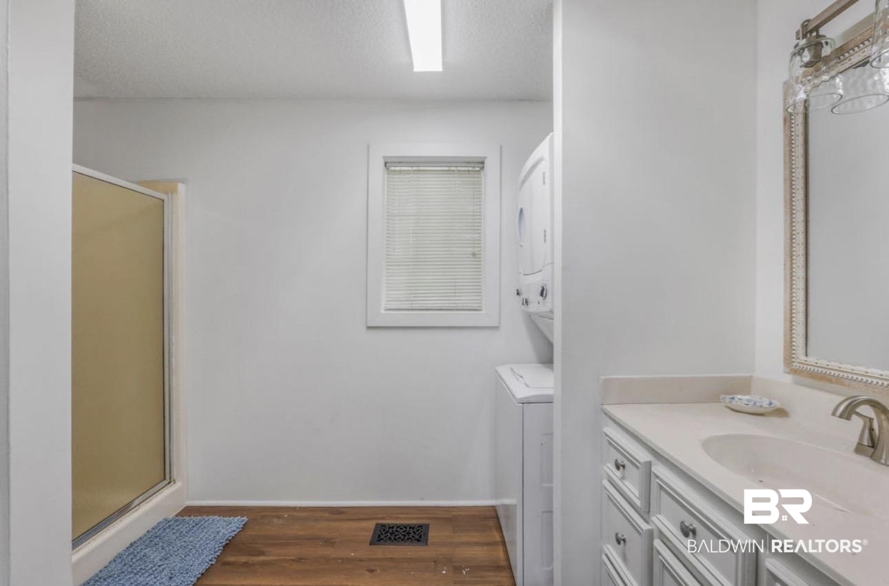 11326 County Road 26 Foley, AL 36535 - Photo 16 of 20 Full bathroom with a shower stall, vanity, dark wood finished floors, stacked washer and dryer, and a textured ceiling