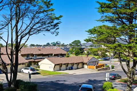 a front view of a house with garden and trees