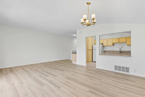 a view of a livingroom with wooden floor and a chandelier