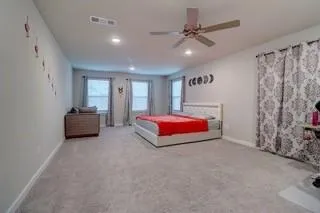 a spacious bedroom with a bed and a chandelier