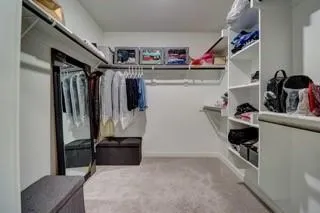 a view of walk in closet with clothes and shoes