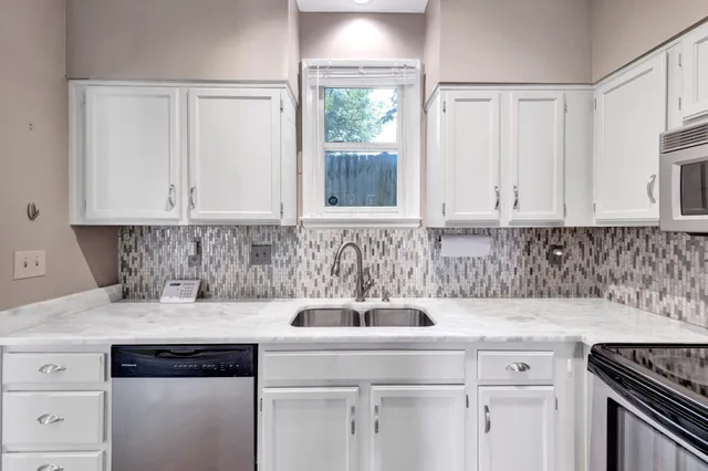 a kitchen with appliances a sink and cabinets