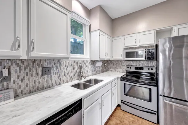 a kitchen with a refrigerator sink and cabinets