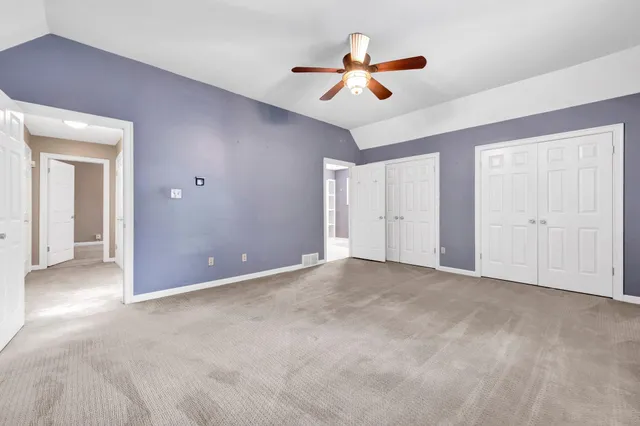 a view of an empty room with a ceiling fan and a window