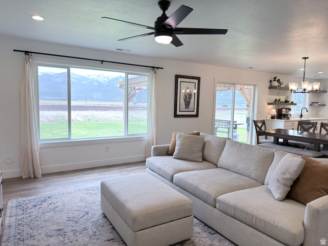 3607 South Parkinson Road South Franklin, ID 83237 - Photo 3 of 24 Living room featuring a ceiling fan, wood finished floors, and suspended lighting