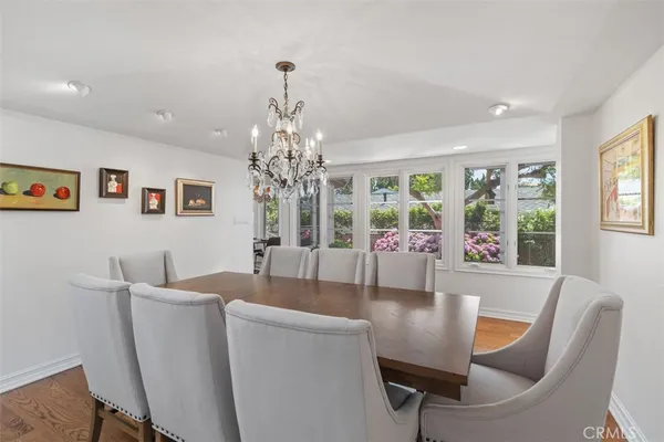 a dining hall with stainless steel appliances kitchen island granite countertop a dining table chairs and view living room