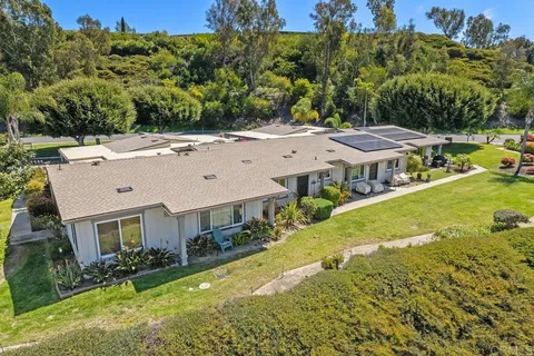 an aerial view of residential houses with yard and mountain view in back yard