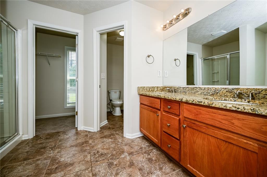 4468 Abram Way Conley, GA 30288 - Photo 8 of 23 a spacious bathroom with a granite countertop sink and a mirror