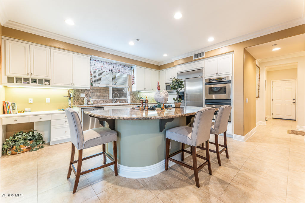 14176 Maya Circle Moorpark, CA 93021 - Photo 13 of 53 a kitchen with a dining table chairs and refrigerator