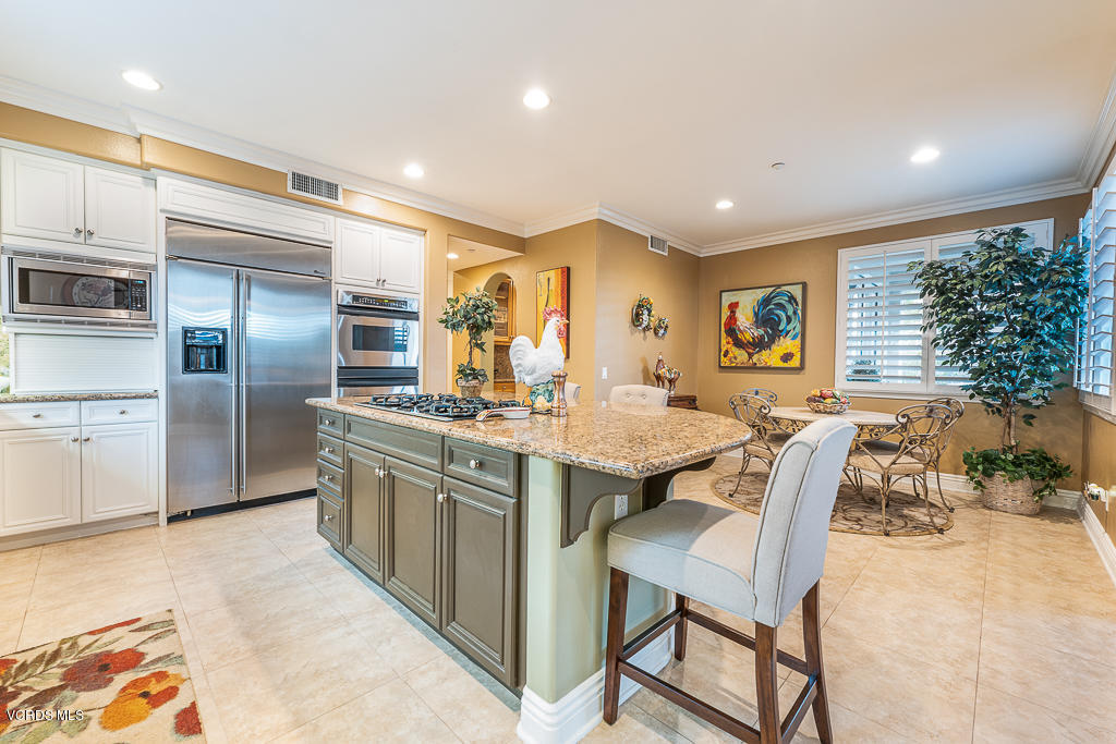 14176 Maya Circle Moorpark, CA 93021 - Photo 17 of 53 a kitchen with stainless steel appliances granite countertop a table chairs sink and cabinets
