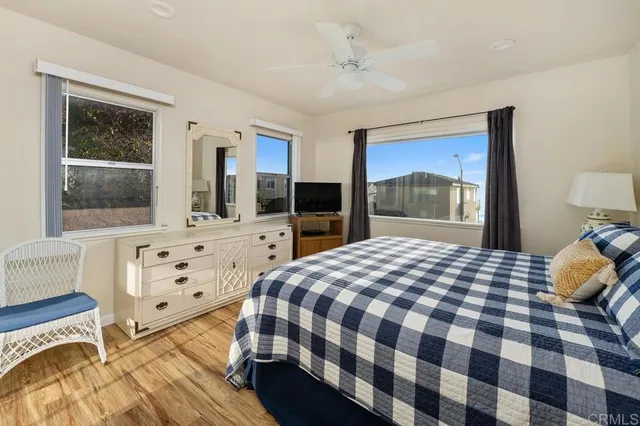 a bedroom with a bed and a flat tv screen next to a window