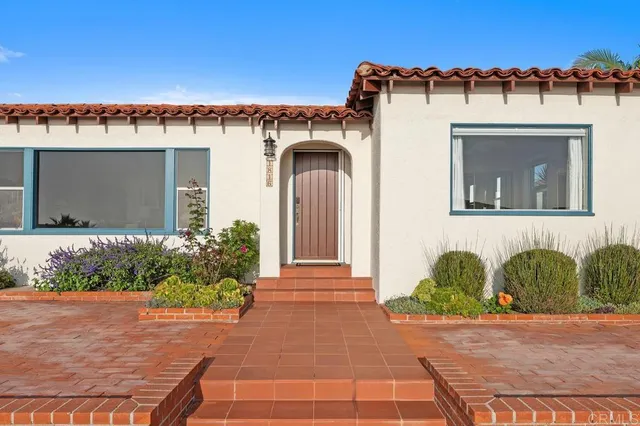 a front view of a house with plants