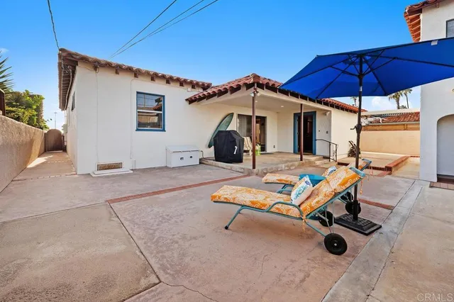 a couple of blue chairs sitting under a blue umbrella