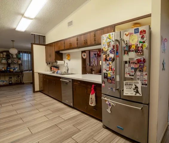 a kitchen with stainless steel appliances granite countertop a refrigerator and a sink