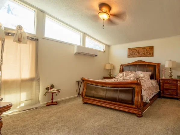 a spacious bedroom with a bed and a chandelier